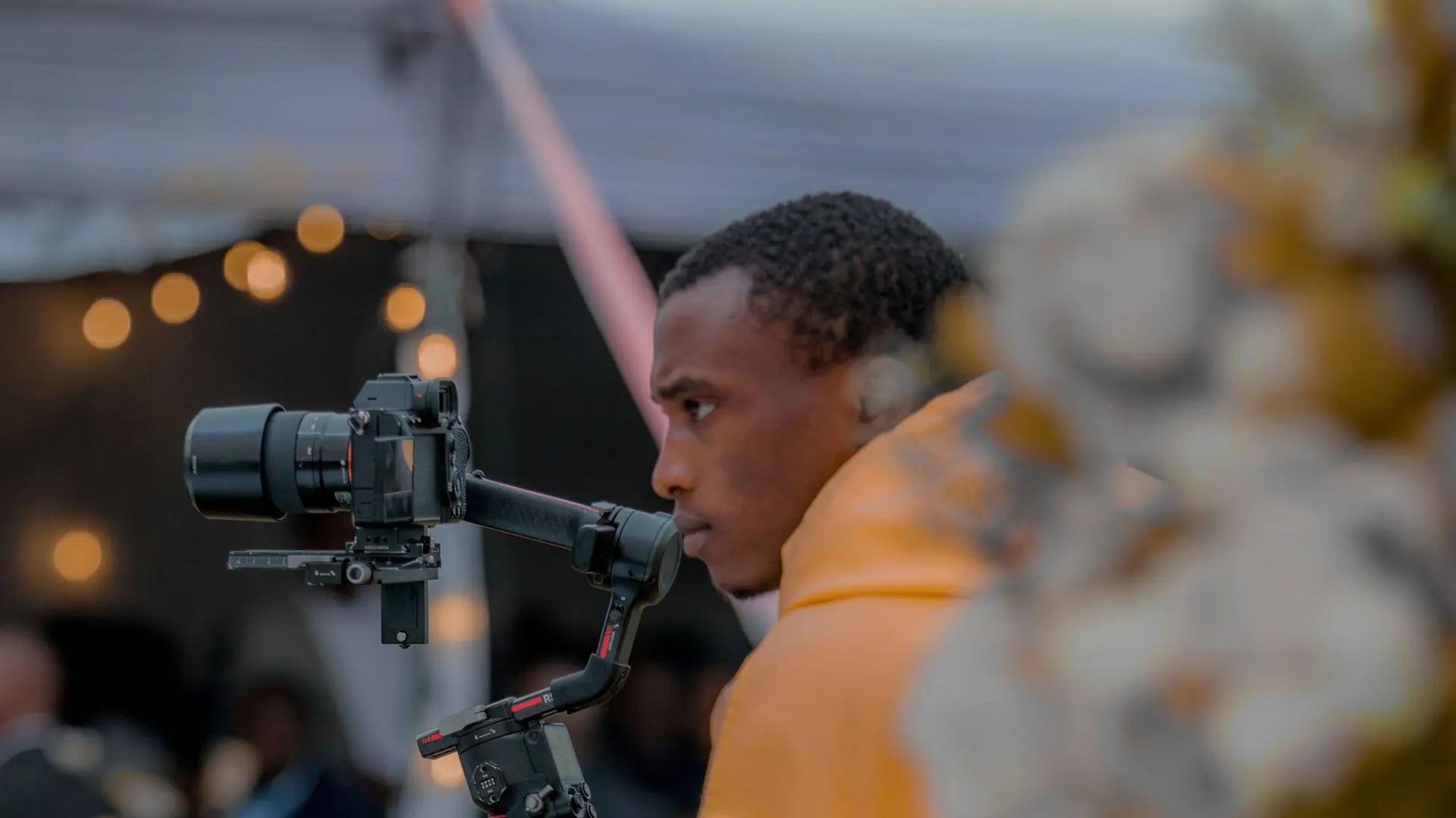 Videographer operating a professional camera gimbal while filming on location